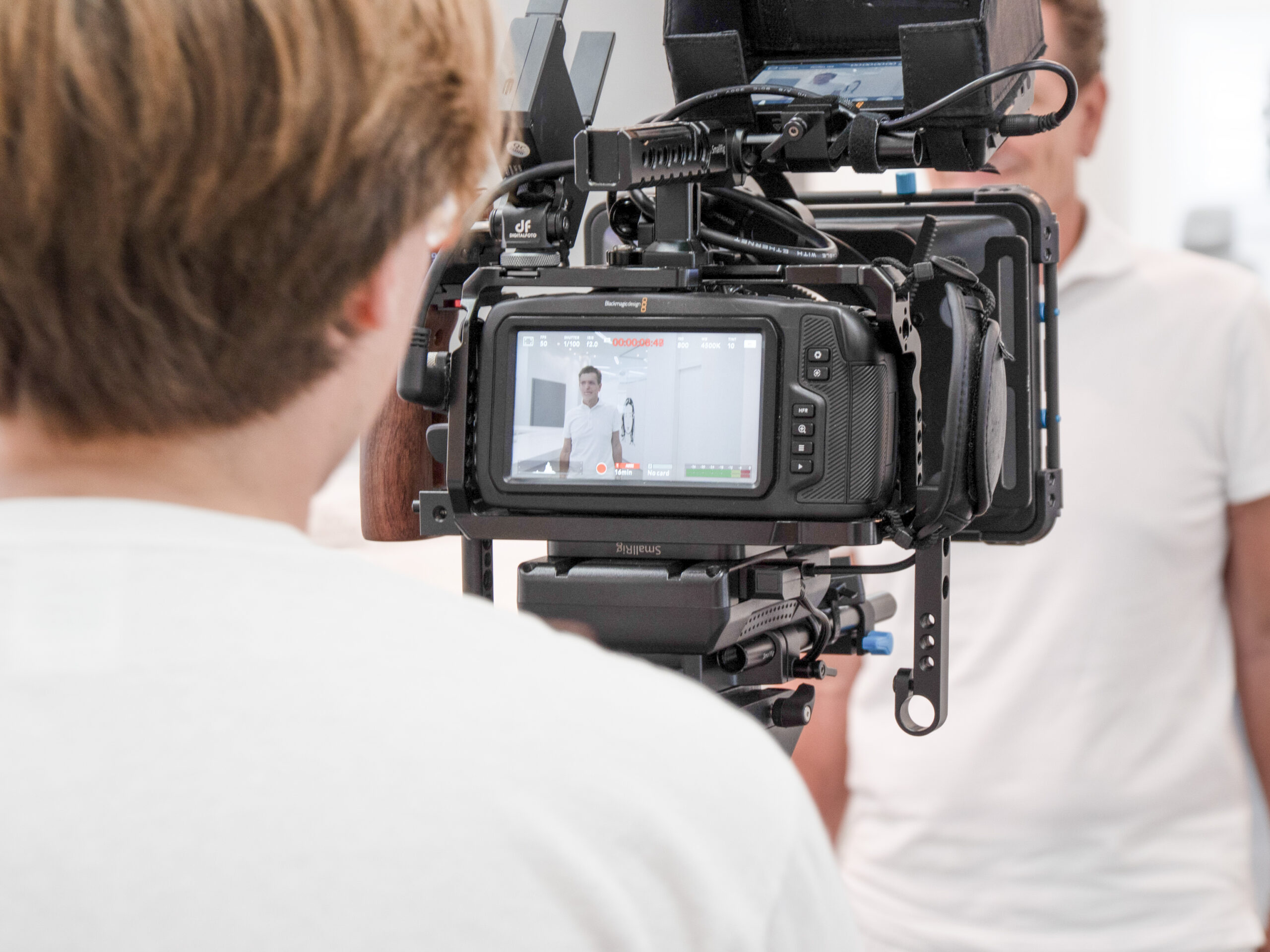 Kamera filmt Person im weißen Raum.