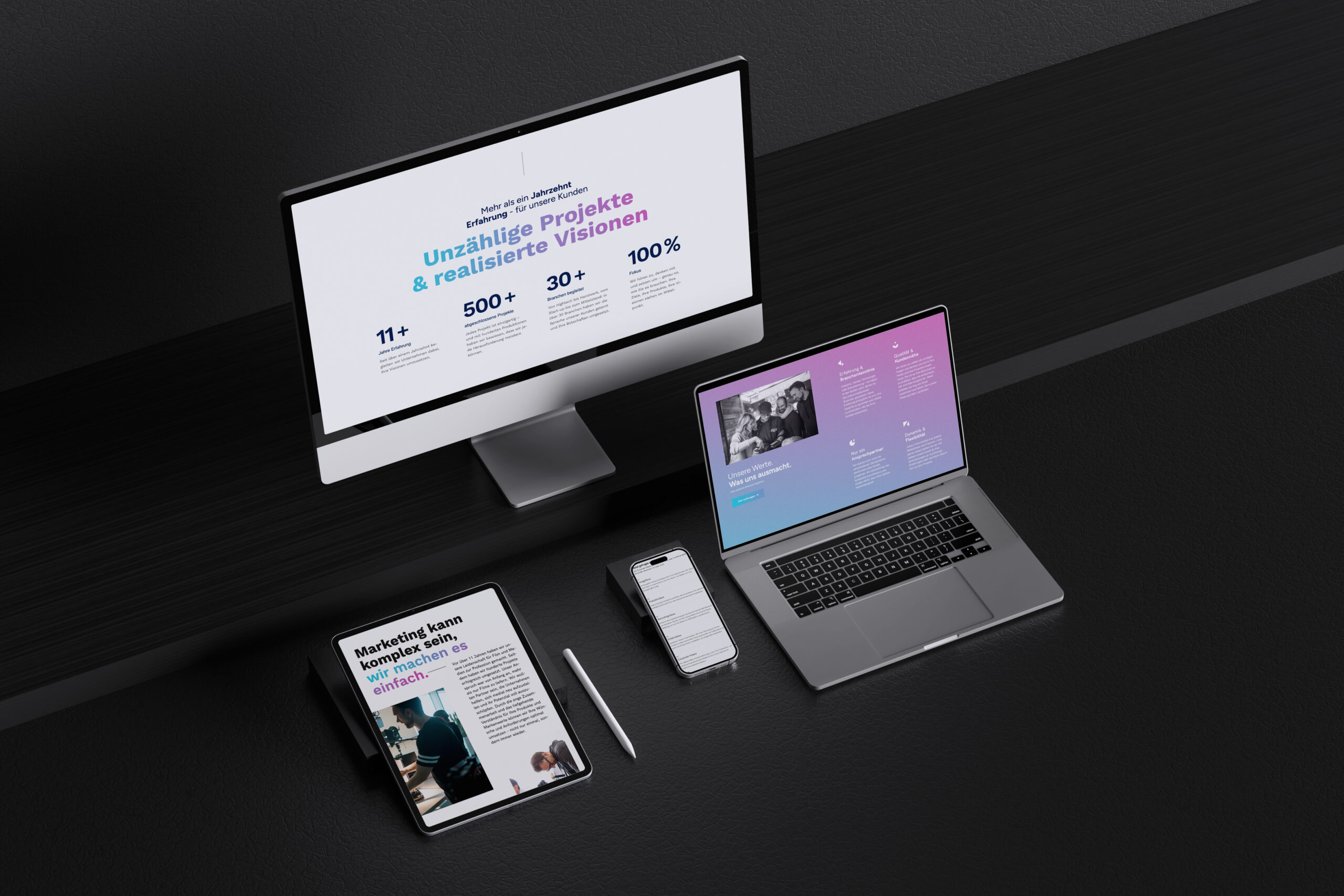 Digitales Schreibtisch-Setup mit Monitor, Laptop, Tablet, Smartphone.