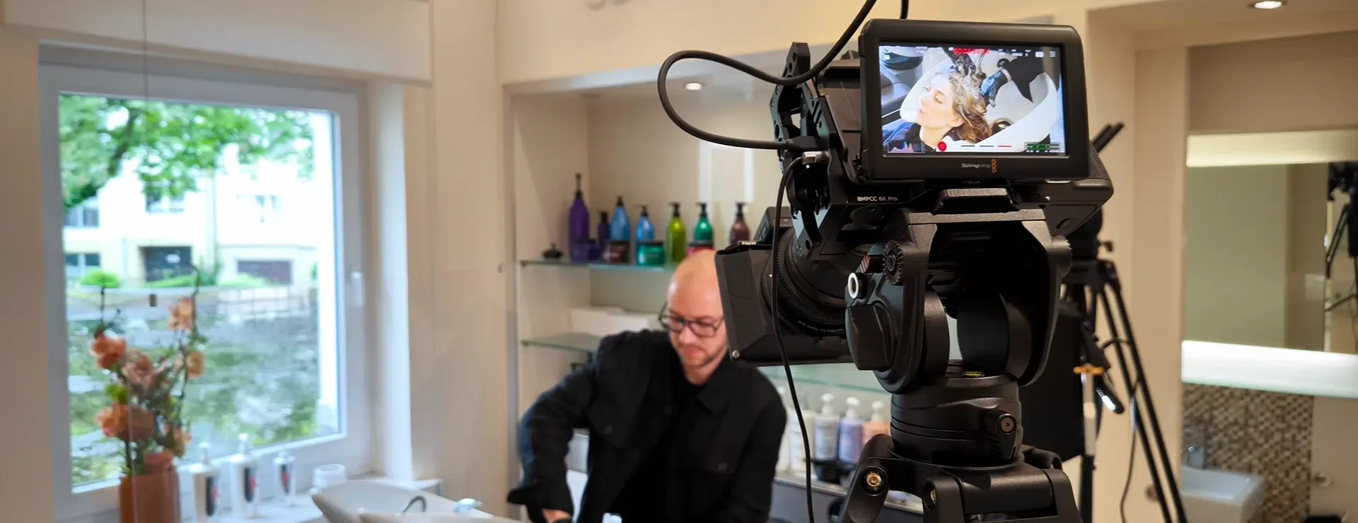 Kameramann filmt Haarbehandlung in Friseursalon