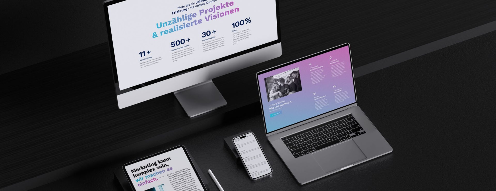 Digitales Schreibtisch-Setup mit Monitor, Laptop, Tablet, Smartphone.